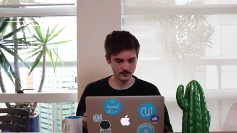 A laptop, coffee mug, and notebooks